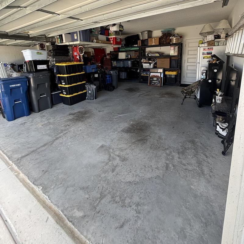 The same garage after, with bins stacked and shelves organized around an open floor
